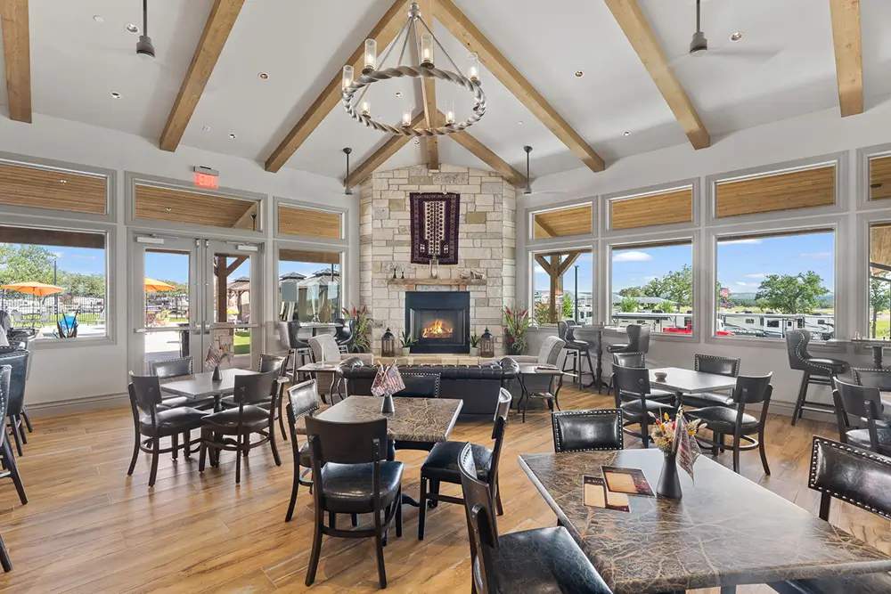 Clubhouse lounge with tables and a stone fireplace