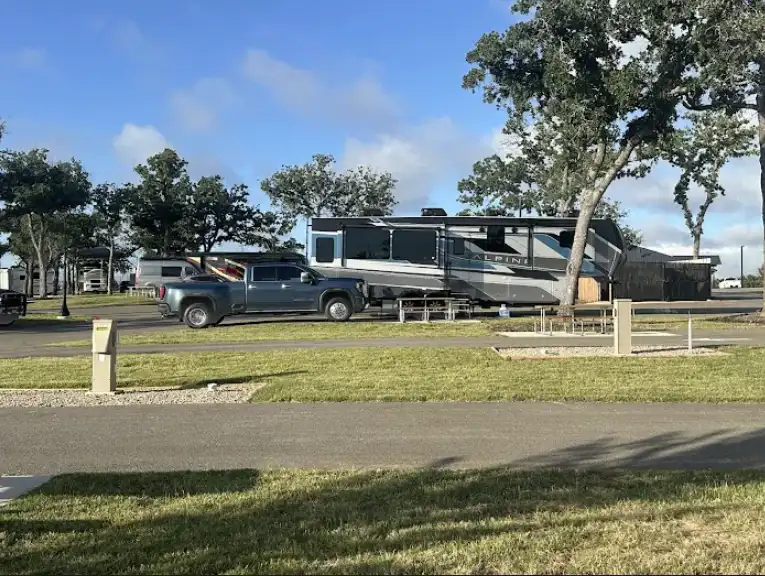 RV parked at a shaded site at Lantern Oaks RV Resort