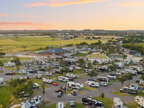Aerial view at golden hour of RV sites filled with motorhomes and trailers at Lantern Oaks RV Resort