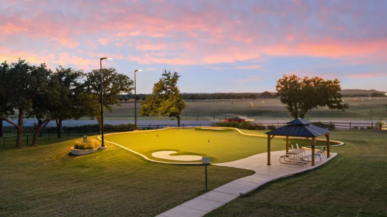 Putting green and gazebo under live oaks at sunset at Lantern Oaks RV Resort