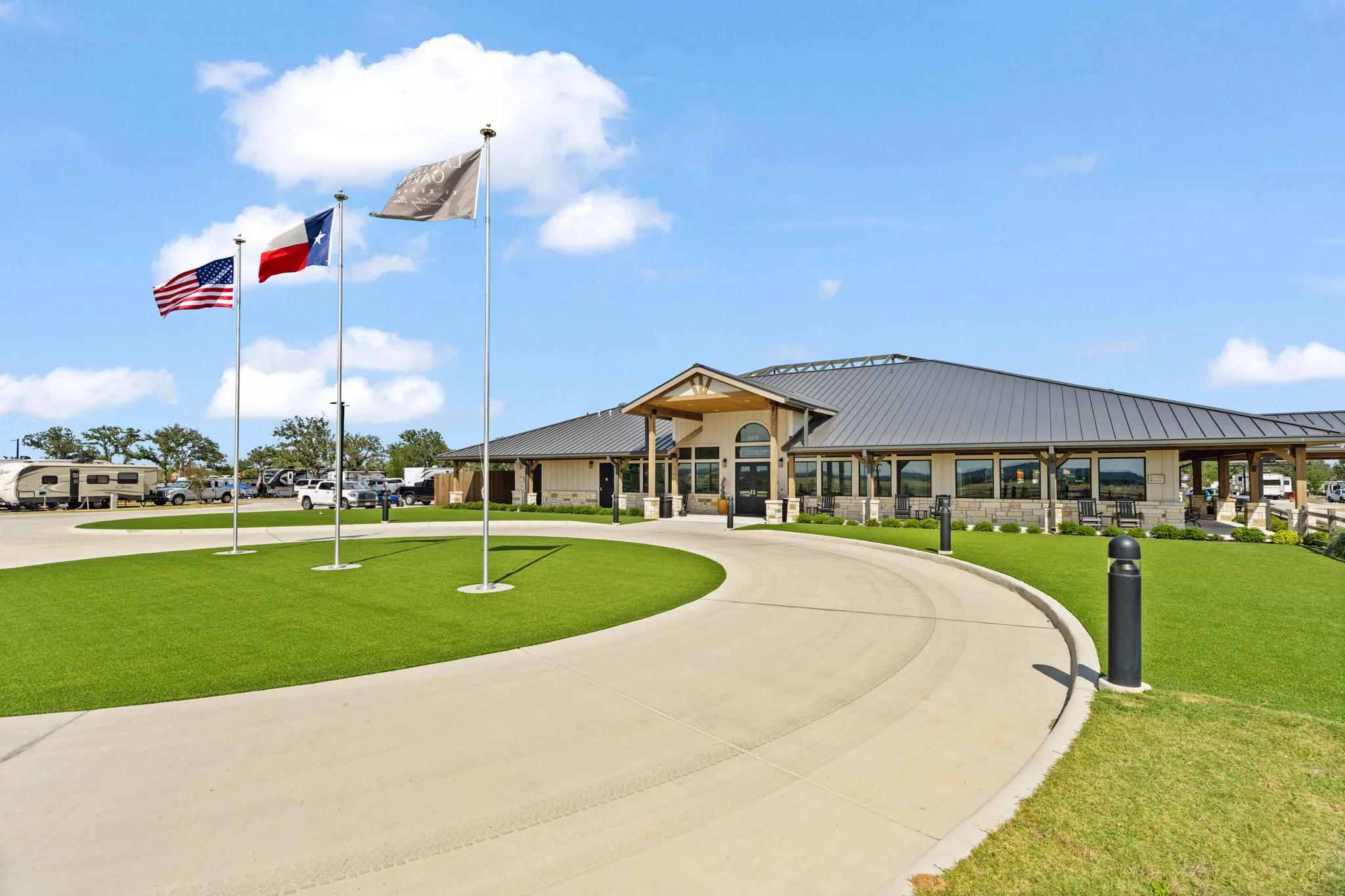Clubhouse and walking path with flags at Lantern Oaks RV Resort